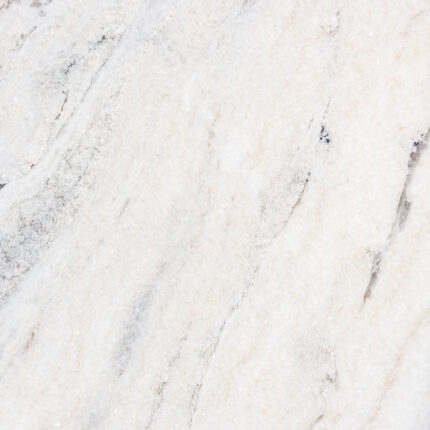 a close-up of a light-colored natural stone with a speckled pattern of grey and beige tones, featuring a polished and glossy surface.