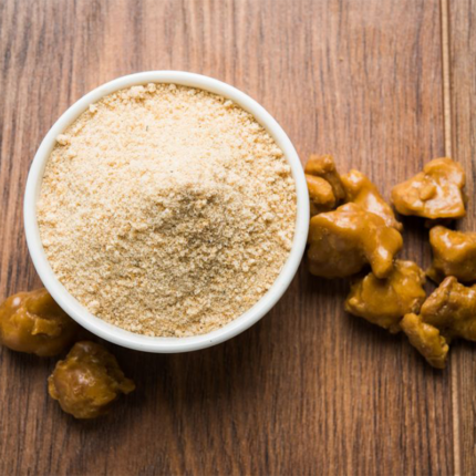 Image of asafoetida powder in a small bowl, a pungent spice used in Indian cuisine, with its distinct yellow color.