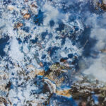 a close-up of a natural stone with a predominantly blue-gray color, featuring fine white and black veins and small mineral deposits, with a polished surface that highlights its unique texture and pattern.