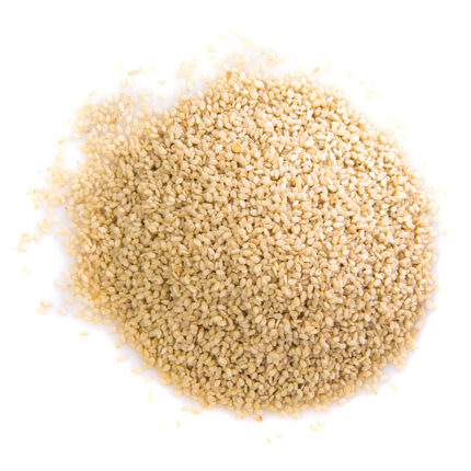 "Close-up of natural sesame seeds on a white background, showing their small, oval shape and light beige color.