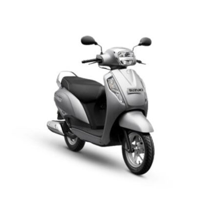 The scooter features sleek body design, large wheels, and a spacious seat. It has a digital instrument cluster, front and rear disc brakes, and LED headlights. The rider is smiling, indicating a joyful riding experience.