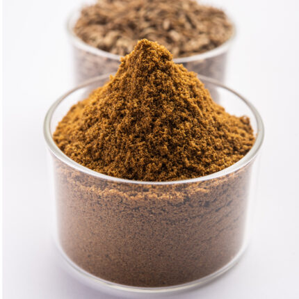 A pile of brownish-yellow, fine powder, likely cumin, with a slightly granular texture.