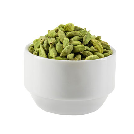 Green cardamom pods in a bowl, commonly used as a fragrant and flavorful spice in baking and cooking, known for their distinct sweet and floral taste.