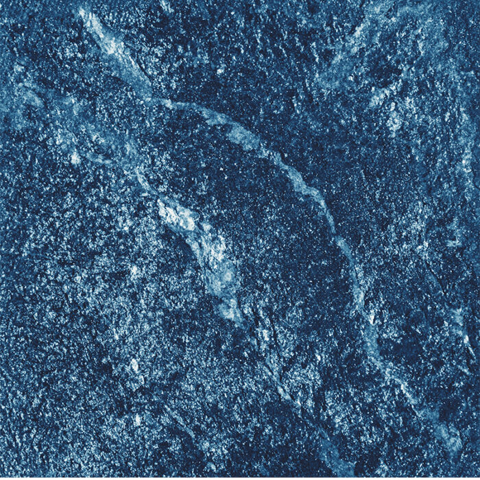 A High-Resolution View Of The Granite'S Deep Blue Surface With Speckled White And Black Patterns, Resembling The Shimmering Beauty Of A Sapphire Gemstone.