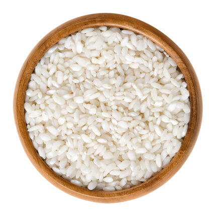 Bomba rice grains are round and pearly white in color. The image may show a bowl of cooked Bomba rice or a pile of uncooked rice grains. Bomba rice is known for its ability to absorb large amounts of liquid while retaining its shape and texture, making it ideal for paella.