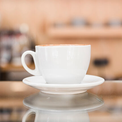The cup has a cylindrical shape with a handle for easy holding, while the saucer is a flat plate-like dish.