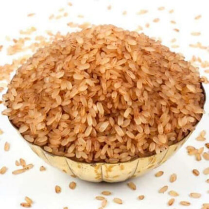 The grains of Palakkadan Matta rice are medium in length and have a reddish-brown color. The image may show a bowl of cooked Palakkadan Matta rice or a pile of uncooked rice grains.