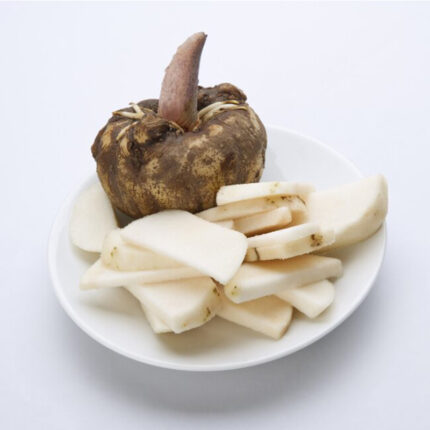 "An image of konjac, a plant commonly known for its starchy corms. Konjac corms are round and bulbous, with a brown outer layer. The image may also show konjac noodles or konjac powder, which are popular konjac-derived products. Konjac is used as a food ingredient and has gained popularity as a low-calorie, low-carbohydrate alternative to traditional pasta and rice. It is known for its gelatinous texture and ability to absorb flavors well.