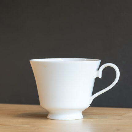 The coffee cup is typically made of ceramic, porcelain, or glass, and may feature a handle for easy holding.