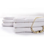 A milky white towel made of soft and absorbent fabric. The towel has a pristine white color, giving it a clean and fresh appearance